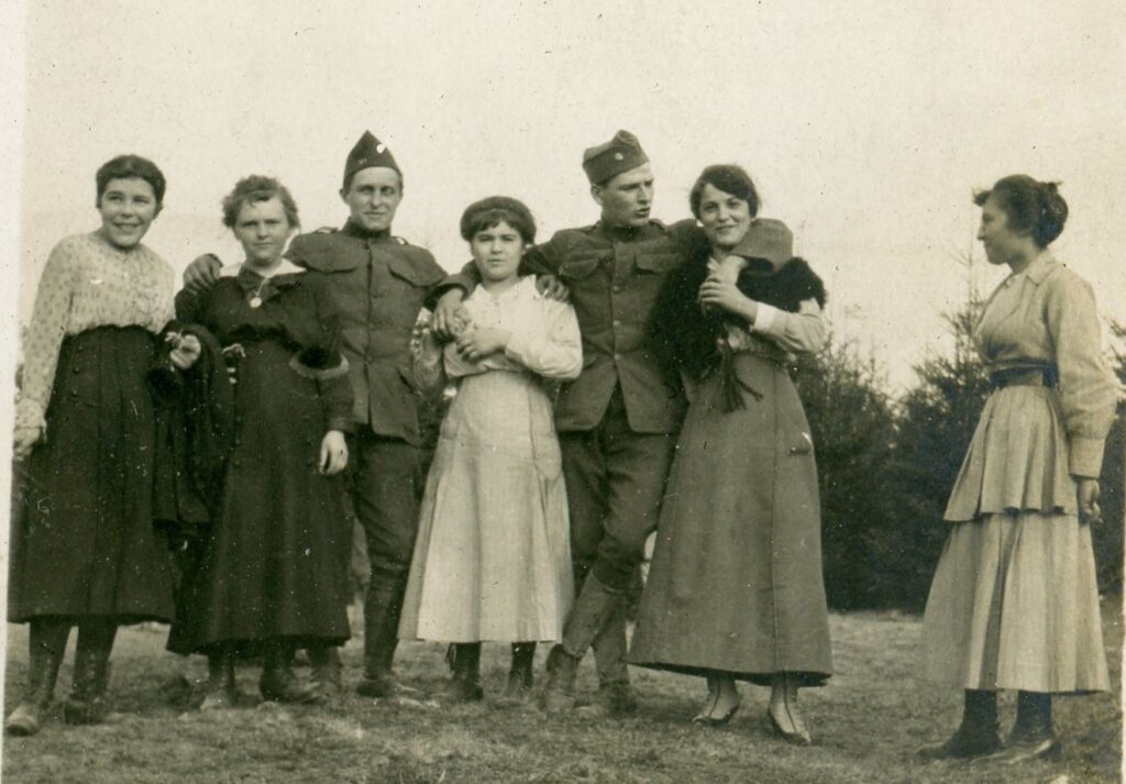 A group of French women and girls posing with two American soldiers